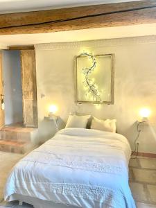 1 dormitorio con 1 cama blanca grande y 2 lámparas en La Maison du Trident en Camargue Piscine et Jacuzzi en Vauvert