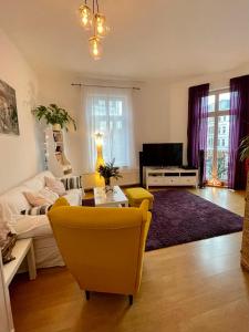 ein Wohnzimmer mit einem Sofa und einem TV in der Unterkunft «Breakfast at Tiffany's» in Leipzig