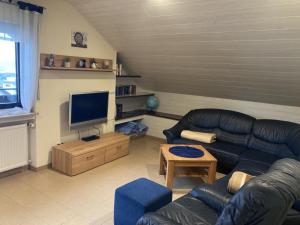 een woonkamer met een bank en een televisie bij Ferienwohnung "Casa Horife" in Konz