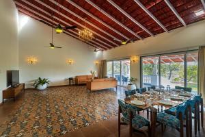 カルジャットにあるSaffronStays Mariposa by the River Montana, Karjatのテーブルと椅子のあるダイニングルーム