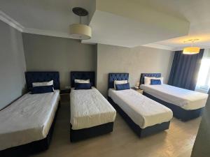 una camera con tre letti e sedie blu di Seher HOTEL a Istanbul