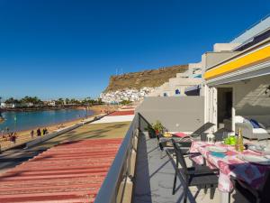 a balcony with tables and chairs and a beach at Mogan Beach Blue Sky in Mogán