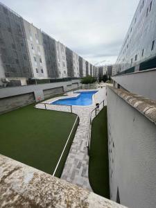 a building with two swimming pools in a courtyard at MuroHouse Apartamento con piscina Fibra1Gb Wifi Garaje in Zaragoza