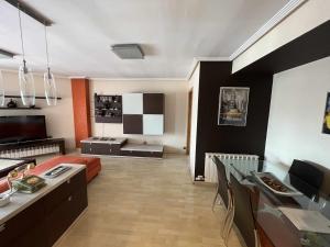 uma sala de estar com um sofá e uma sala de jantar em MuroHouse Apartamento con piscina Fibra1Gb Wifi Garaje em Zaragoza