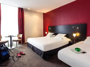 een hotelkamer met 2 bedden en een tafel bij Grand Hôtel des Thermes Brides-les-Bains in Brides-les-Bains