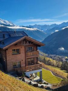 una casa en una colina con montañas al fondo en Panorama Lodge, en Fliess