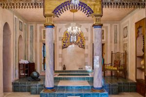 a lobby with columns and a chandelier in a building at Al Moudira Hotel in Luxor