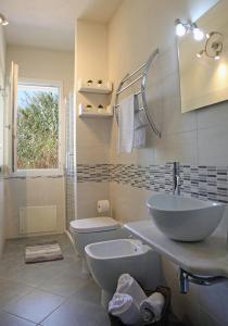 een badkamer met een wastafel en een toilet bij Casa Bianca Marea in Santa Maria Navarrese