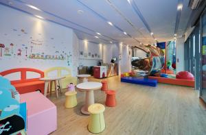 una sala de juegos para niños con mesas y sillas en Orient Luxury Hotel en Chiayi