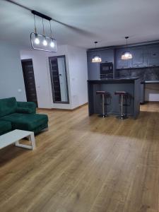 a living room with a green couch and a kitchen at ApartHotel Dominic Residence in Alba Iulia