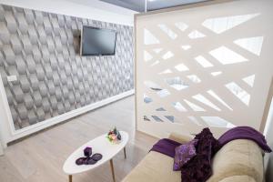a living room with a couch and a tv at White home in Timişoara