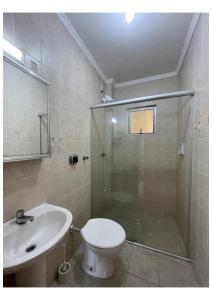 uma casa de banho com um chuveiro, um WC e um lavatório. em AP com Piscina em Porto Belo em Porto Belo