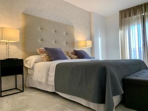 a bedroom with a large bed with a large headboard at Benabola Hotel & Suites in Marbella