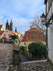 een geplaveide straat in een stad met een straatlicht bij Altstadtjuwel in Meißen