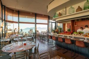 a restaurant with tables and chairs with a view of the ocean at Hôtel & Spa Belle Plage in Cannes