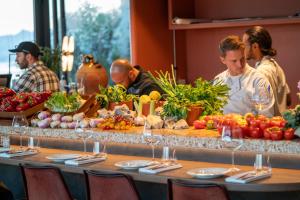 a group of people standing around a table with fruits and vegetables at Hôtel & Spa Belle Plage in Cannes
