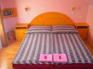 Una cama con dos almohadas rosas encima. en Penzion u Balcarky, en Ostrov u Macochy