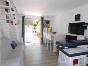 una camera con cucina con tavolo e scala di Mazet provencal au coeur des Alpilles La Rêverie a Maussane-les-Alpilles