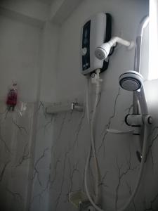 uma casa de banho com um chuveiro e um secador de cabelo na parede em Sena Home em Ambalangoda