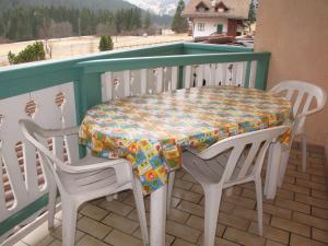 een tafel en vier stoelen op een balkon met een tafel en stoelen bij Villa Marta in Mazzin