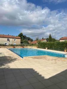 una grande piscina in un cortile con una casa di Mazet provencal au coeur des Alpilles La Rêverie a Maussane-les-Alpilles
