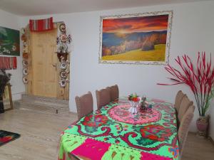 un comedor con una mesa con un colorido mantel en Casa de la ferma Mariuca, en Berbeşti
