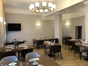 a dining room with tables and chairs and a chandelier at Milbor Hotel in Bad Soden am Taunus