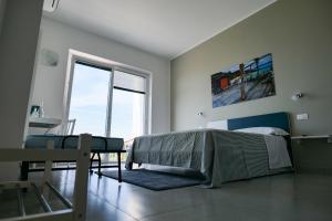 a bedroom with a bed and a table with a chair at Villa Caravaggio Comfort e Relax in Rocca San Giovanni