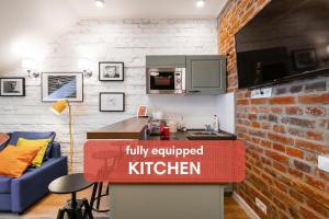 a kitchen with a table and a brick wall at Revelton Studios Marianske Lazne in Mariánské Lázně