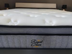 Una cama con un colchón blanco con una señal de mamá real. en Silver Pearl Apartment, en Potamós