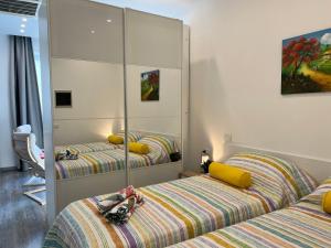 ein Schlafzimmer mit zwei Betten und einem Spiegel in der Unterkunft Bnbook Monolocale Gandhi in Rho