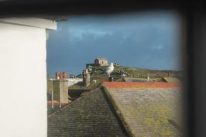 a bird sitting on the roof of a building at Stylish Two Bedroom Cottage - In Town Centre in St Ives