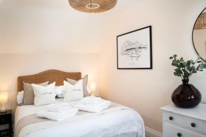 a bedroom with a white bed with towels on it at Stylish Two Bedroom Cottage - In Town Centre in St Ives