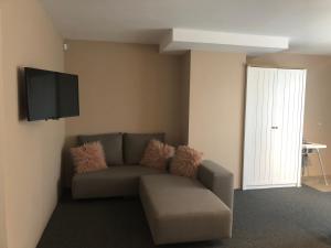 a living room with a couch and a flat screen tv at Lavender Suite 