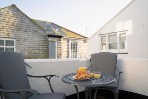 a table with a plate of food on a patio at Stylish Two Bedroom Cottage - In Town Centre in St Ives