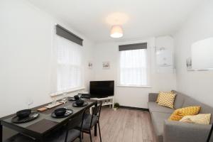 sala de estar con mesa y sofá en LARGE GROUPS- 5 bed House in Harringay, en Londres