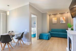un soggiorno con divano blu e tavolo di Maravilla - By Impero House a Baveno