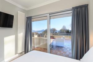 a bedroom with a bed and a sliding glass door at Maravilla - By Impero House in Baveno