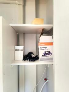 a white shelf with a box and books on it at Central Petone, lovely 4 bedroom in Lower Hutt