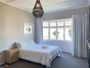 a bedroom with a bed and a large window at Central Petone, lovely 4 bedroom in Lower Hutt