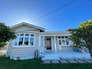 une maison blanche avec une terrasse couverte dans l'établissement Central Petone, lovely 4 bedroom, à Lower Hutt