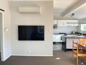 a kitchen with a flat screen tv on a wall at Central Petone, lovely 4 bedroom in Lower Hutt