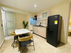 a kitchen with a small table and a refrigerator at The Host at Santa Marta in Santa Marta