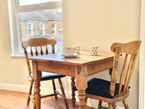 un tavolo di legno con due sedie e due tazze sopra di Russets Rest a York