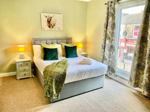 una camera da letto con un letto con cuscini verdi e una finestra di Russets Rest a York