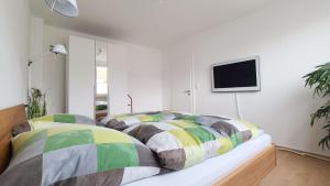 - une chambre avec un lit et une télévision murale dans l'établissement Deine Oase mitten in Hannover., à Hanovre