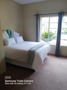 - une chambre avec un grand lit et une fenêtre dans l'établissement Pythons Guest Lodge, à Rustenburg