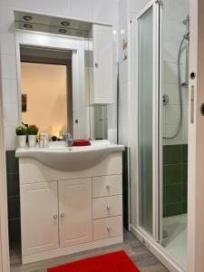 ein Badezimmer mit einem weißen Waschbecken und einer Dusche in der Unterkunft Bnbook Monolocale Gandhi in Rho