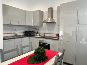 eine Küche mit weißen Schränken und einem Tisch mit einer Pflanze darauf in der Unterkunft Bnbook Monolocale Gandhi in Rho + 16 Fotos