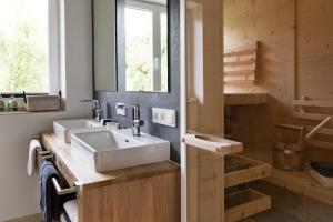 a bathroom with two sinks and a mirror at Bewegte Berge Apartments in Saalfelden am Steinernen Meer